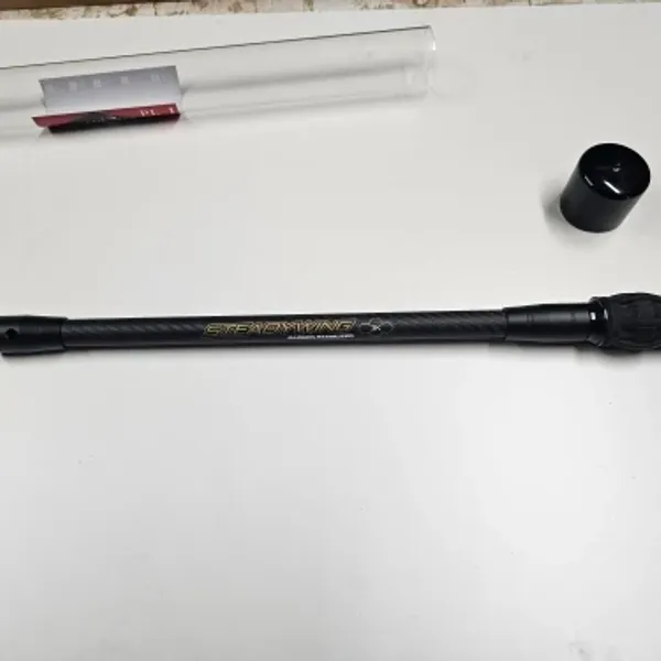Carbon bow stabilizer with stainless steel counterweight and packaging tube on a white table — unedited verified buyer photo (Poland)